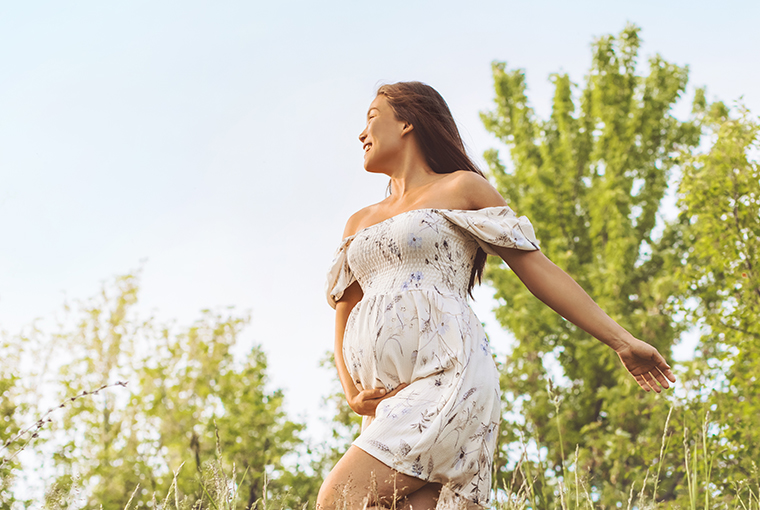 Es ist eine schwangere Frau mit erhöhtem Vitamin-B12-Bedarf in der Natur zu sehen.