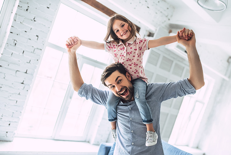 Eine ausreichende Versorgung mit dem Vitamin B12 hilft dem jungen Vater aktiv zu bleiben und mit seiner Tochter nach Feierabend zu spielen.